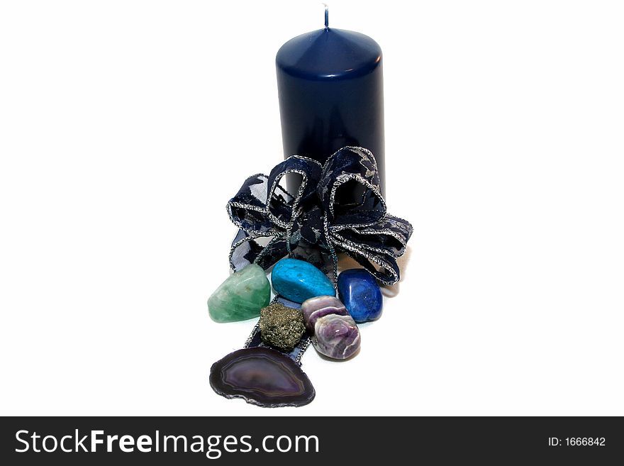 Blue candle with some precios stones and a decorative ribbon