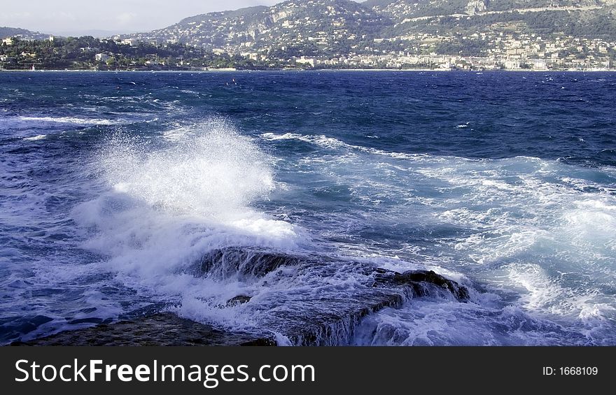 Swept up mediterranean sea water exploding on boulders on the coast. Swept up mediterranean sea water exploding on boulders on the coast