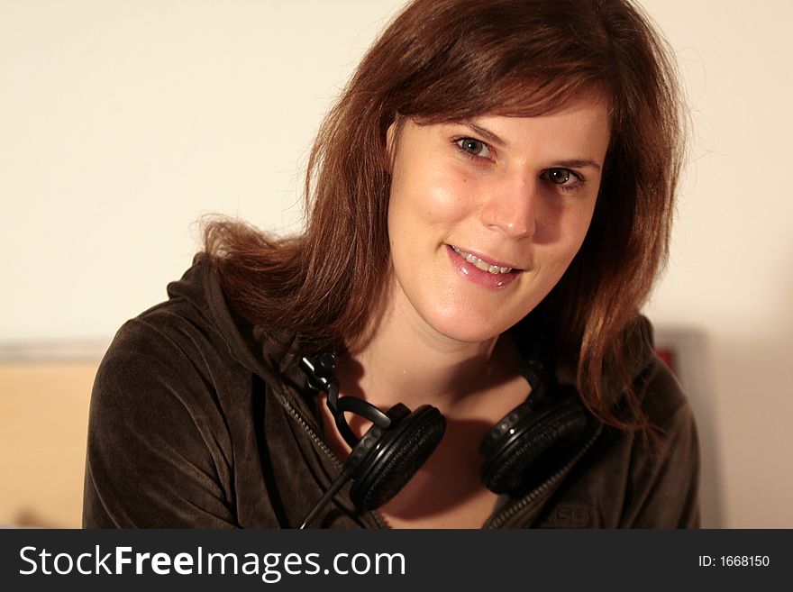 A young trendy woman with her headphones around her neck. A young trendy woman with her headphones around her neck.