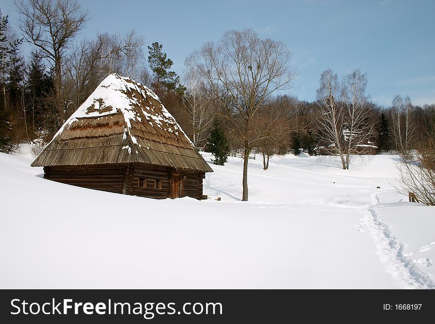 Wooden rural house in the snowy countryside landscape. Wooden rural house in the snowy countryside landscape