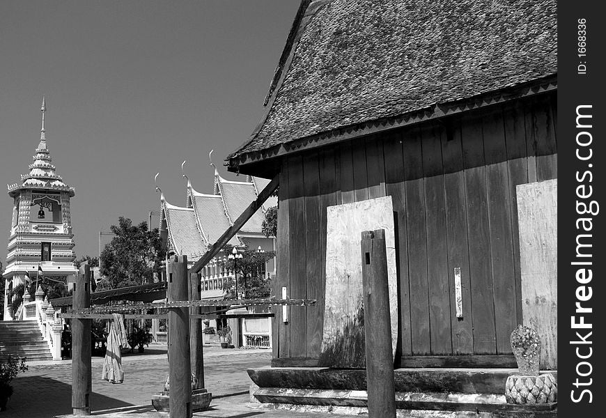 Black and white image of Buddhist temple in Thailand with old, unrestored temple-building in the foreground. Black and white image of Buddhist temple in Thailand with old, unrestored temple-building in the foreground.