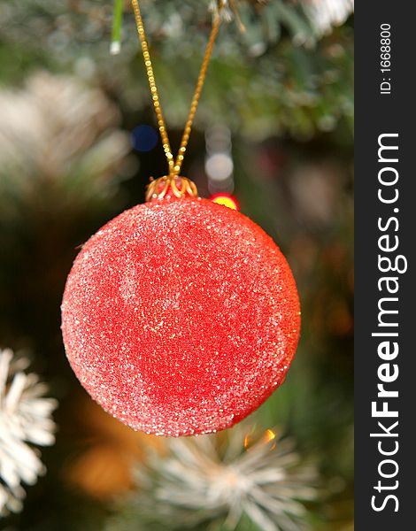 Christmas decorative ball with tree and lights in background