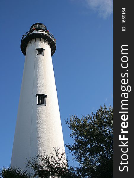 A white lighthouse against the blue sky at beach. A white lighthouse against the blue sky at beach