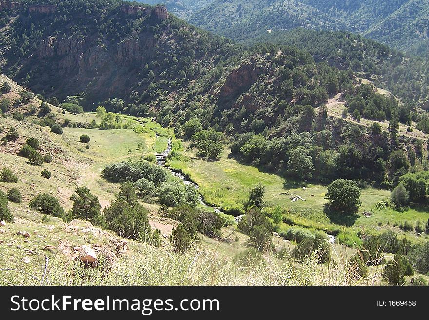 A view from high colorado mountains. The road joins CaÃ±on City and Victor in central Colorado, USA. Summer grass and trees. A view from high colorado mountains. The road joins CaÃ±on City and Victor in central Colorado, USA. Summer grass and trees