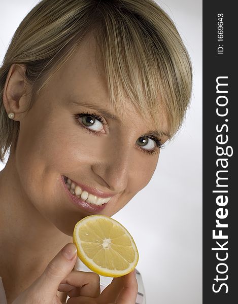 Young women with lemon slice in hand close up