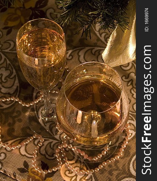 Two glasses with vine in it on the ornamental tea-cloth