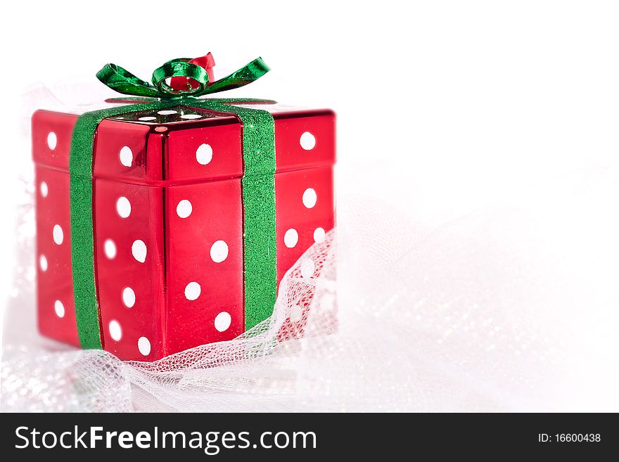 Red shiny polka dot Christmas present on shimmery fabric. Red shiny polka dot Christmas present on shimmery fabric