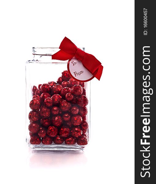 Candy jar with red glittery candy, and gift tag isolated on white with copy space