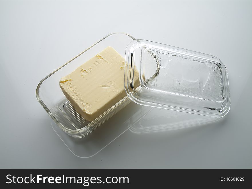Butter in a buterdish made of glass on a table