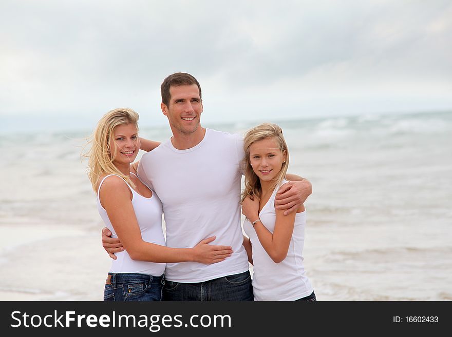 Couple and daughter standing by the sea. Couple and daughter standing by the sea