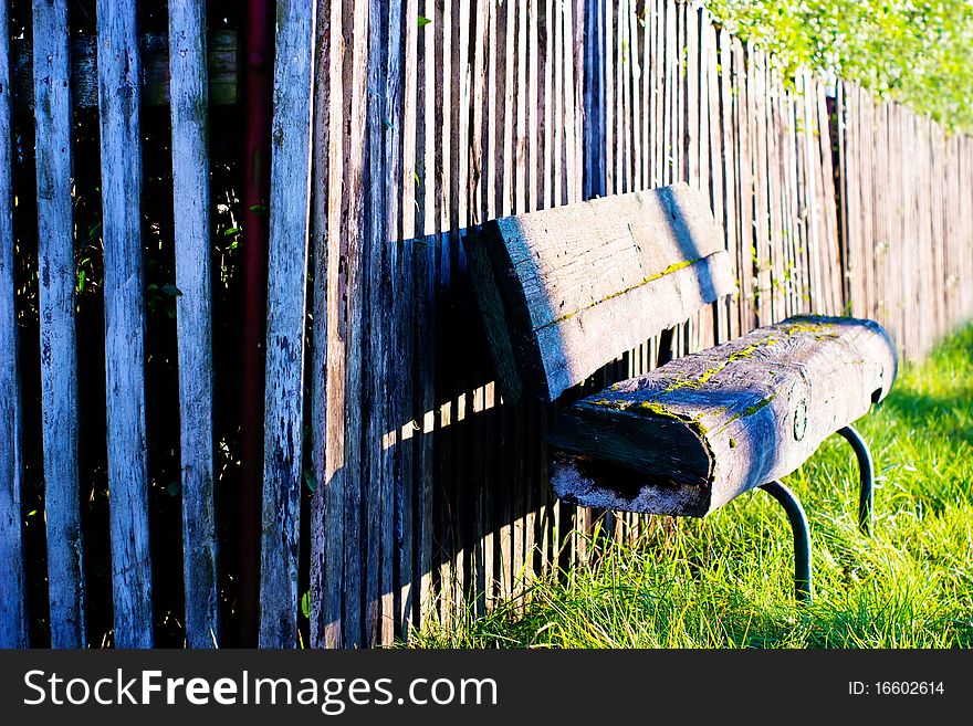 Old wooden boundary fence with nails on sunny day