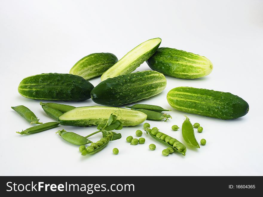 Vegetables peas and cucumbers on the white background. Vegetables peas and cucumbers on the white background