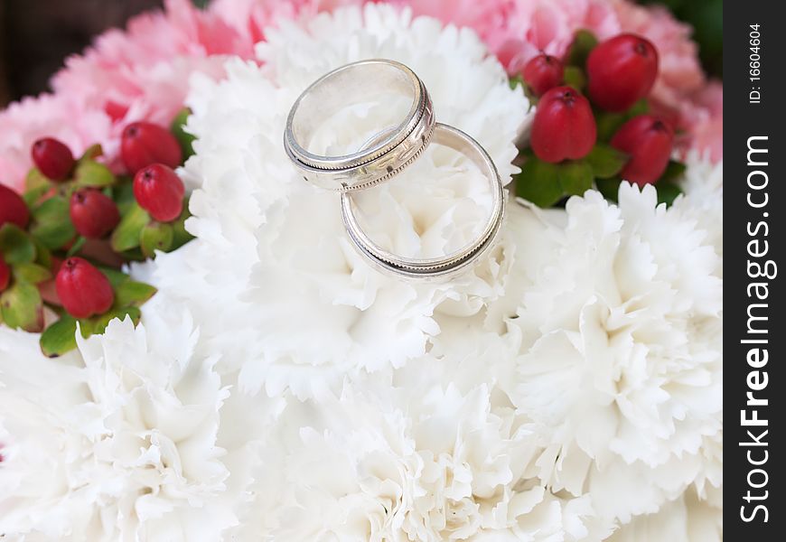 Closeup of wedding rings and flowers