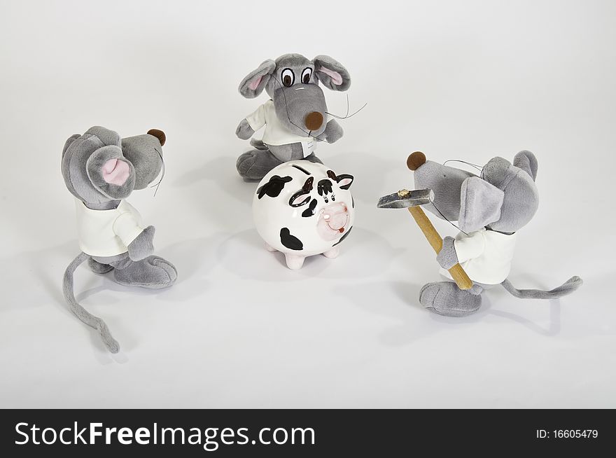 This image shows three soft toys with a hammer to break a piggy bank. This image shows three soft toys with a hammer to break a piggy bank