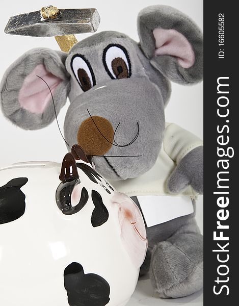 This image shows a soft toy with a hammer to break a piggy bank. This image shows a soft toy with a hammer to break a piggy bank