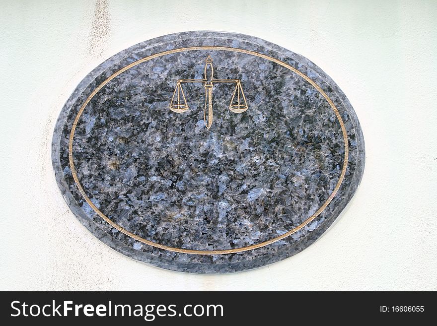 Blank and Empty Mable Plate with Golden Scale of justice on White Wall at Street