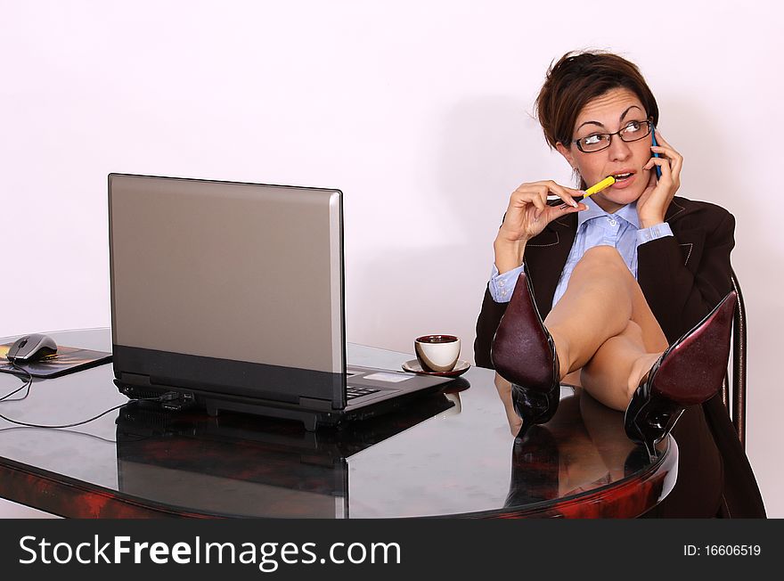Attractive secretary sitting and talking on cell phone