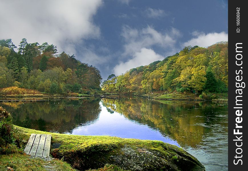 Still waters surrounded by autumnal trees. Still waters surrounded by autumnal trees