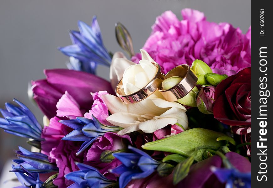 Closeup of wedding rings on a bouquet