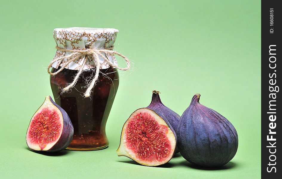 Figs and jar with fig jam on background. Figs and jar with fig jam on background