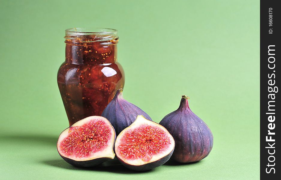 Figs and jar with fig jam on background. Figs and jar with fig jam on background