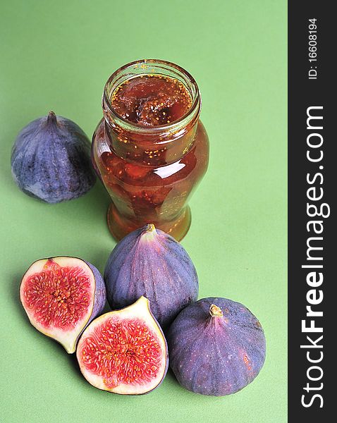 Figs and jar with fig jam on background. Figs and jar with fig jam on background