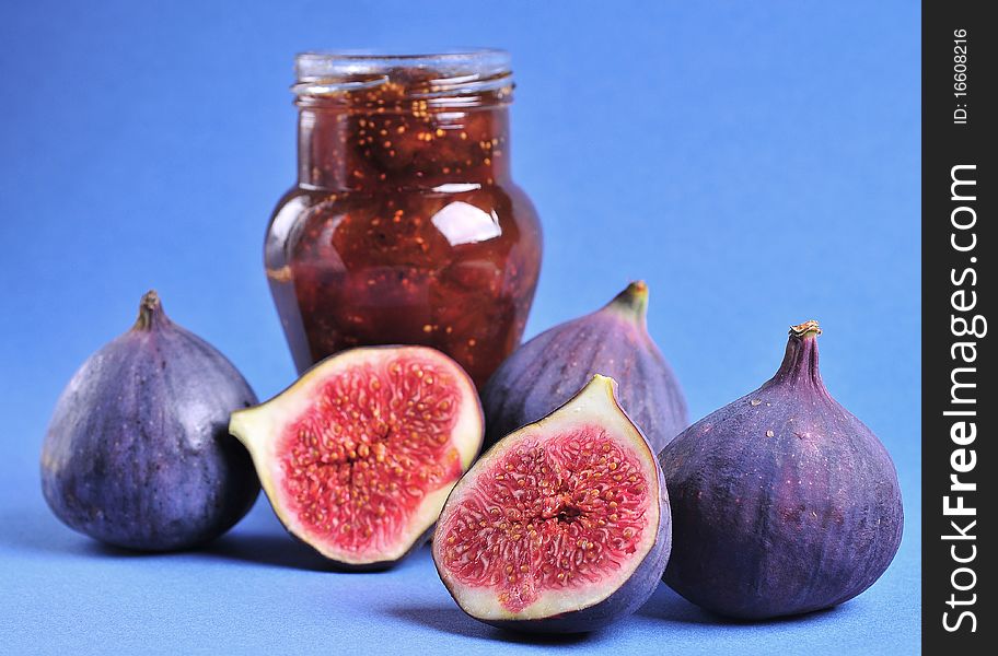 Figs and jar with fig jam on background. Figs and jar with fig jam on background