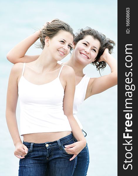 Two young happy girls on sea background