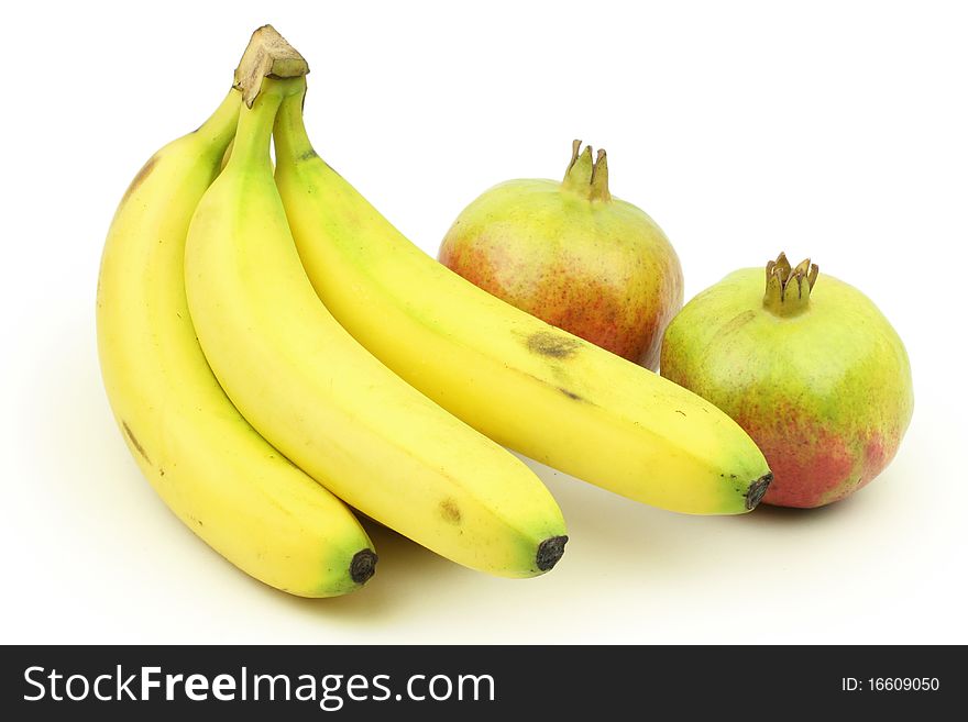 Pomegranates with bananas on a white background