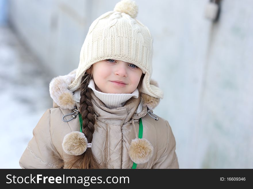 Adorable winter small girl in whitr warm hat and jacket i