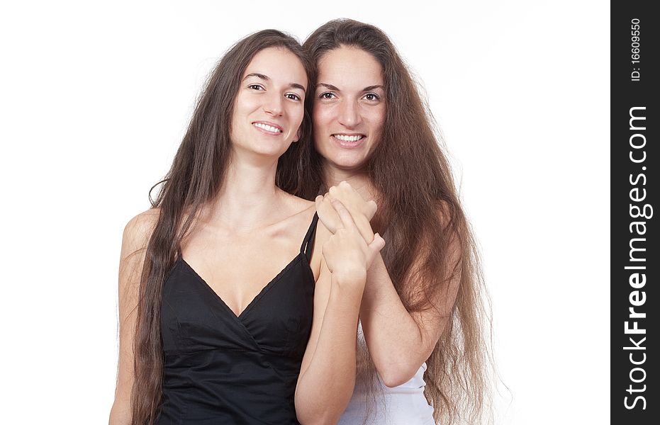 Two sisters with very long brown hair standing smiling - isolated on white. Two sisters with very long brown hair standing smiling - isolated on white