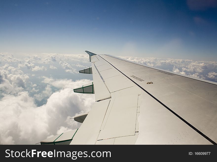 Wing of an airplane as it soars through the sky. Wing of an airplane as it soars through the sky