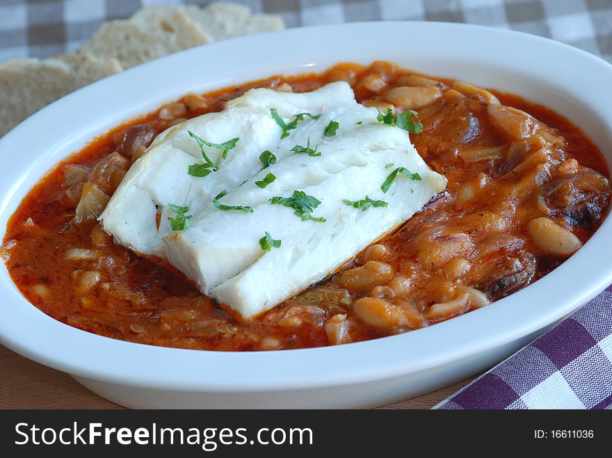 Cod fillet with spicy beans in a dish. Cod fillet with spicy beans in a dish