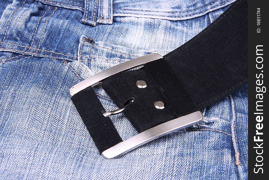 The man's black leather belt lies on jeans. The man's black leather belt lies on jeans