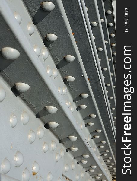 Steel construction fastened with rivets - industrial background. Shallow depth of field