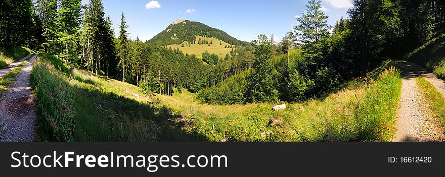 The peak of the mountain Hochstafl in the Reisalpe region in Lower Austria with a gravel road in the foreground. The peak of the mountain Hochstafl in the Reisalpe region in Lower Austria with a gravel road in the foreground