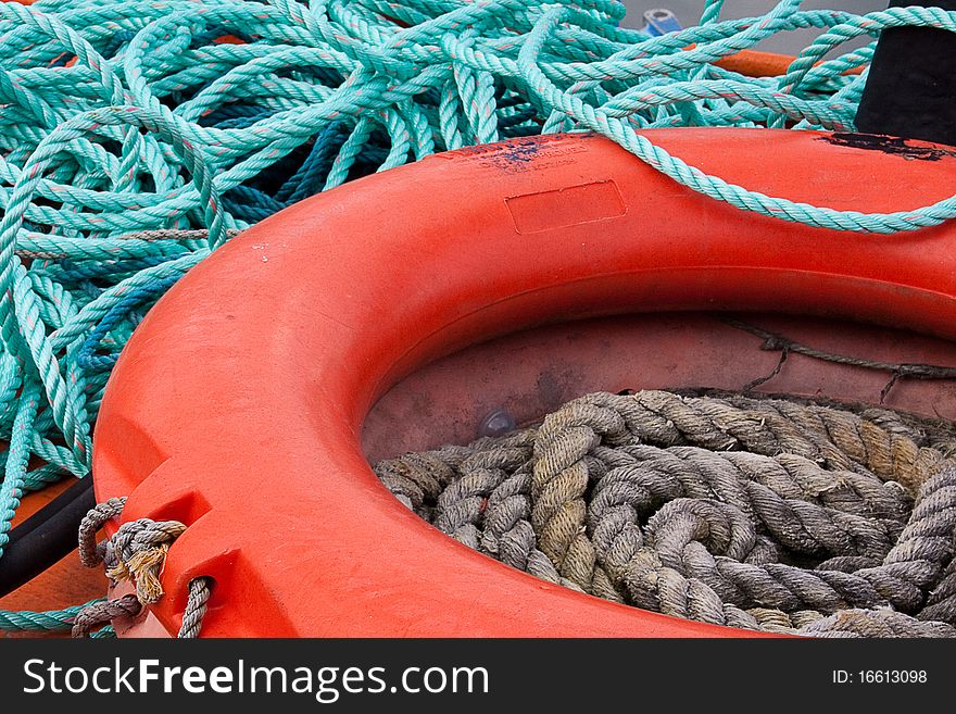 An orange lifebelt and blue rope on the wheelhouse of a fishing vessel in The Barbican harbour, Plymouth, Devon, UK. An orange lifebelt and blue rope on the wheelhouse of a fishing vessel in The Barbican harbour, Plymouth, Devon, UK
