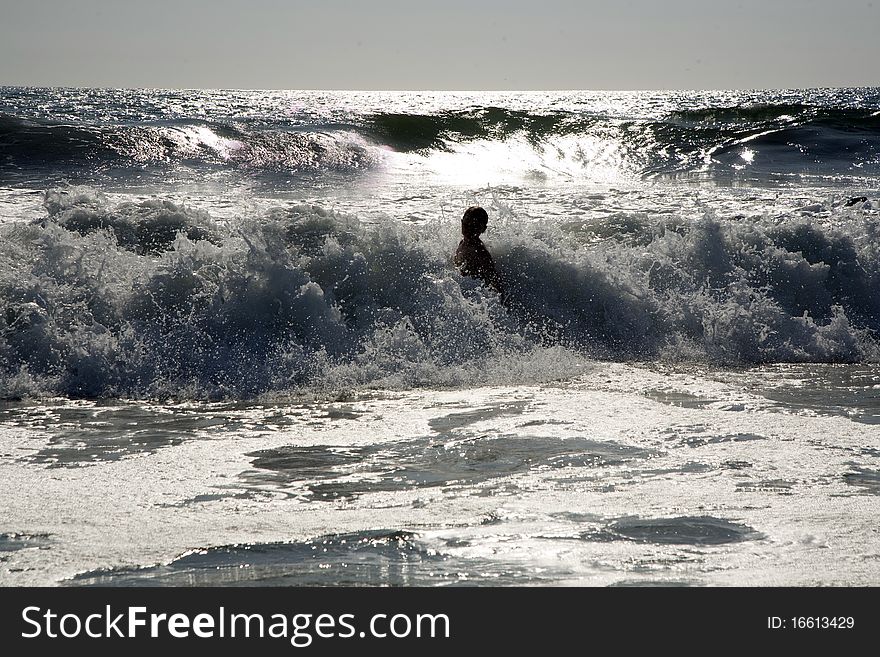 Swimmer in silver light at sunset at Redondo Beach, California