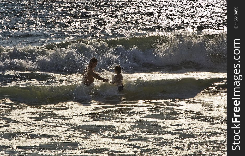 Bathing in sunset in waves at  the beach