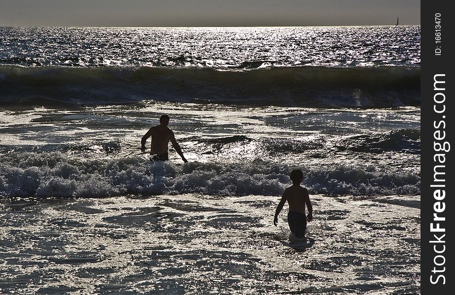 Bathing in sunset in waves at  the beach