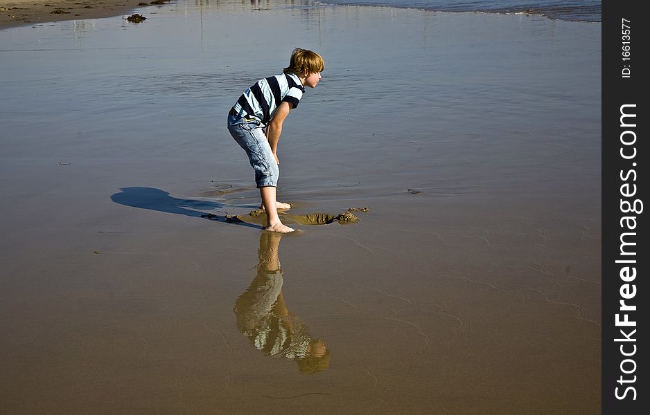 Boy at the beach in Venice with reflecting picture in wet sand