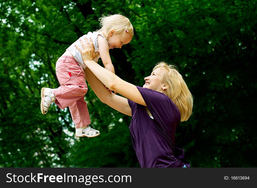 Mother embrace her young daughter in the green citypark. Mother embrace her young daughter in the green citypark