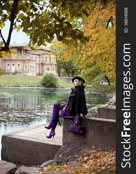 The image of a beautiful girl in a purple dress in the autumn park. The image of a beautiful girl in a purple dress in the autumn park