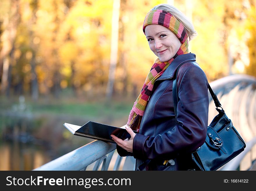 Young woman with book in autumn park