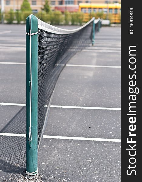 A neighborhood tennis court beside a school.