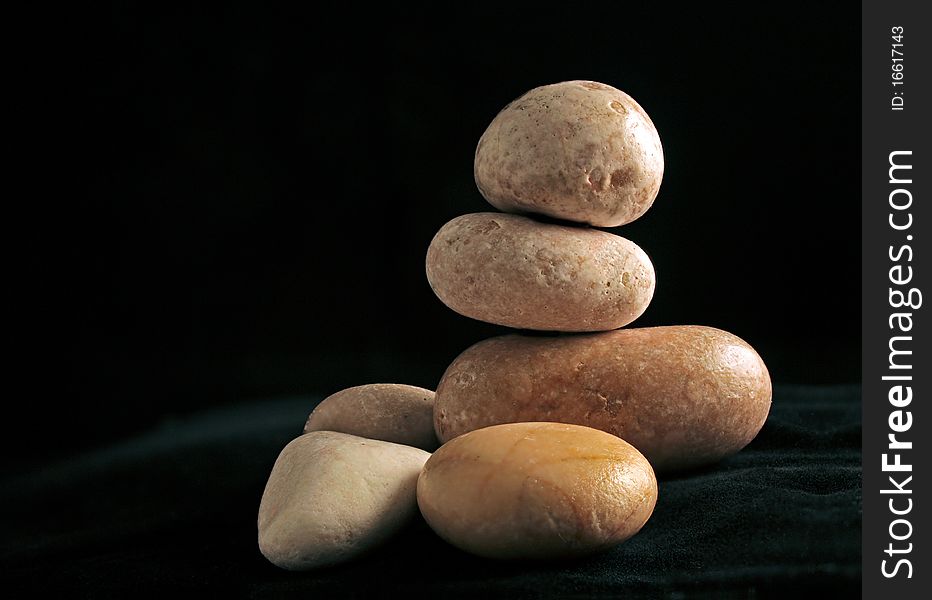 Arrangement with pebbles on dark background, a still life. Arrangement with pebbles on dark background, a still life