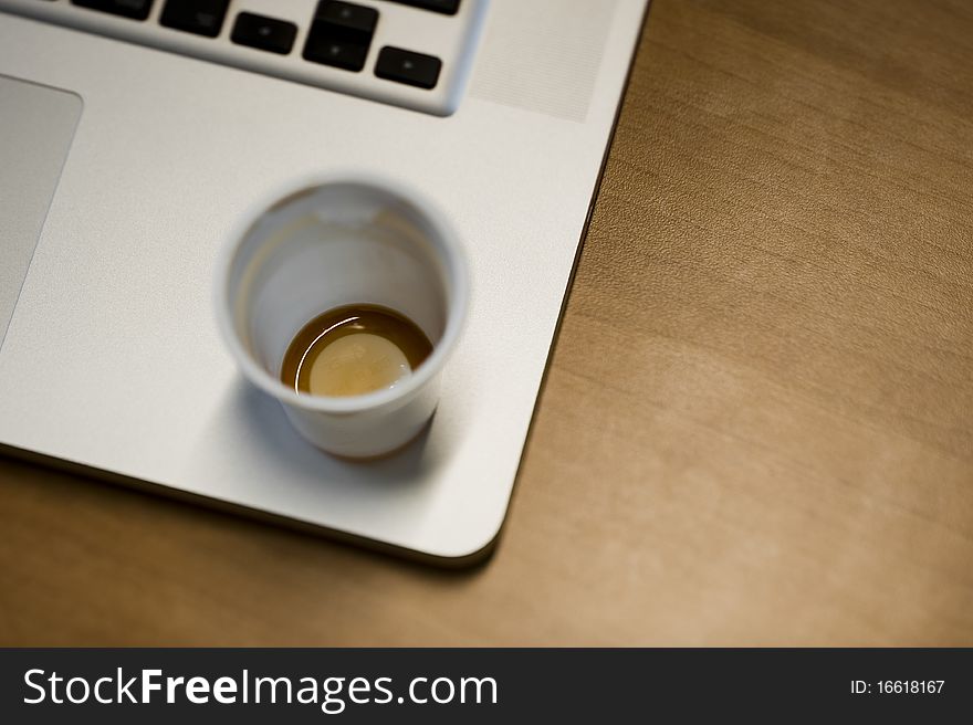 Coffee cup and laptop, on a table