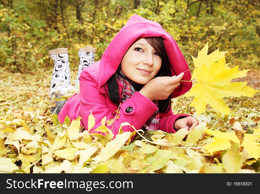 Girl at the hood lies on the yellow the foliage. Girl at the hood lies on the yellow the foliage
