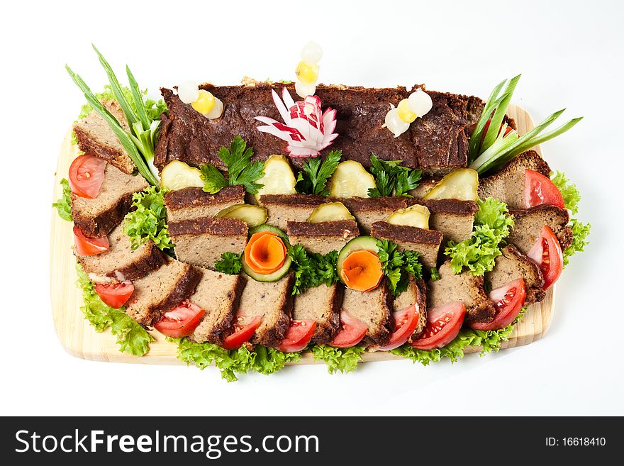 Liver pie decorated vegetables and herbs on white background