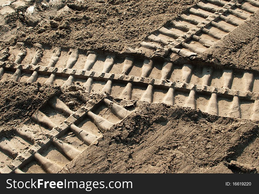 Bulldozer footprints intersect on soil
